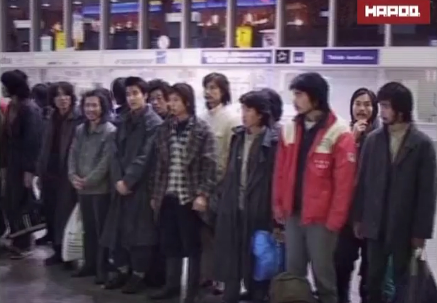 A queue of Asians waiting at an airport