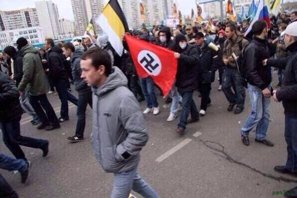 Nazi symbols and nationalist flags at a Russian March rally